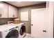 Well-equipped laundry room with modern washer and dryer and ample cabinet space at 719 Crossroad Ct, Powder Springs, GA 30127