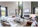 Bright living room with fireplace, high ceilings, luxury furniture, and oversized windows at 719 Crossroad Ct, Powder Springs, GA 30127