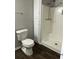 Bright bathroom featuring a toilet, shower, and built-in storage cabinet at 980 Fox Chase Ln, Riverdale, GA 30296