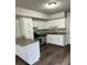 Well-lit kitchen with modern appliances, granite countertops, white cabinets, and wood flooring at 980 Fox Chase Ln, Riverdale, GA 30296