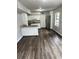 Open-concept kitchen with granite countertops, white cabinets, stainless steel refrigerator, and hardwood floors at 980 Fox Chase Ln, Riverdale, GA 30296