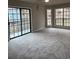 Bright and spacious living room with large windows, a sliding glass door, and new carpeting at 980 Fox Chase Ln, Riverdale, GA 30296