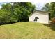 Backyard with a dog art mural and mature trees surrounding the grassy lawn at 1104 Victory Sw Dr, Atlanta, GA 30310