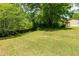 Large grassy backyard with mature trees and partial fencing, offering privacy and space at 1104 Victory Sw Dr, Atlanta, GA 30310