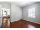 This bedroom has wood-look floors, a window with blinds, and a view into the living room at 1104 Victory Sw Dr, Atlanta, GA 30310