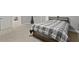 Spacious carpeted bedroom with a metal headboard and a gray plaid comforter with additional room for seating at 896 Winn Rd, Douglasville, GA 30134