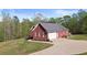Rear view of red brick home features an attached garage and paved driveway at 896 Winn Rd, Douglasville, GA 30134