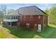 Rear view of red brick home with screened porch, deck, and ample windows at 896 Winn Rd, Douglasville, GA 30134