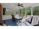Cozy screened-in porch with a ceiling fan, a table with six chairs, and views of the surrounding wooded area at 896 Winn Rd, Douglasville, GA 30134