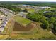 Aerial view of a community with pond, open green space, tennis courts and nearby school at 1259 Fendt Dr, Locust Grove, GA 30248