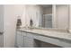 Bathroom featuring granite countertop, large mirror, and shower with glass door at 1259 Fendt Dr, Locust Grove, GA 30248