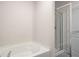Bathroom area showcasing a built-in tub and separate glass-enclosed shower at 1259 Fendt Dr, Locust Grove, GA 30248