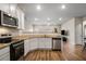 Open-concept kitchen showcases stainless steel appliances, sleek white cabinets, and a view into the living area at 1259 Fendt Dr, Locust Grove, GA 30248