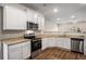 Modern kitchen featuring stainless steel appliances, granite countertops, and white cabinetry with ample storage space at 1259 Fendt Dr, Locust Grove, GA 30248