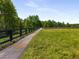 Scenic walking trail surrounded by lush greenery and a black wooden fence, perfect for outdoor recreation at 1259 Fendt Dr, Locust Grove, GA 30248