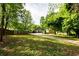 Lush backyard featuring mature trees, green lawn, and a long driveway at 1412 Woodbine Se Ave, Atlanta, GA 30317