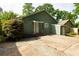 Backyard features a stone patio, lush landscaping, and access to a detached garage at 1412 Woodbine Se Ave, Atlanta, GA 30317