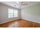 Bright bedroom featuring a ceiling fan, hardwood floors, and a large window overlooking the yard at 1412 Woodbine Se Ave, Atlanta, GA 30317