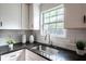 Bright kitchen features white cabinets, granite counters, tiled backsplash, and stainless steel faucet at 1412 Woodbine Se Ave, Atlanta, GA 30317