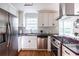 Modern kitchen featuring stainless steel appliances, gas cooktop, and white cabinetry at 1412 Woodbine Se Ave, Atlanta, GA 30317