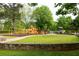 Community playground with colorful equipment, swings, and slides on a lush lawn at 1412 Woodbine Se Ave, Atlanta, GA 30317