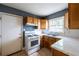 Traditional-style kitchen with white appliances, wooden cabinets, and a bright window at 1594 Lincoln Se Ave, Atlanta, GA 30317