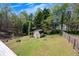 Expansive backyard with shed, partially fenced and surrounded by mature trees, ideal for outdoor activities at 507 Honeysuckle Ln, Woodstock, GA 30188