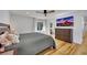 Cozy bedroom features hardwood floors, a ceiling fan, and a modern TV at 507 Honeysuckle Ln, Woodstock, GA 30188