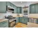 A well-equipped kitchen features stainless appliances, light wood countertops, and green cabinets at 507 Honeysuckle Ln, Woodstock, GA 30188