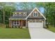 Charming two-story home featuring gray siding, a well-manicured lawn, and an attached two-car garage at 5260 Moore St, Stone Mountain, GA 30083