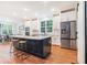 Bright kitchen with stainless steel appliances, white cabinetry, a central island, and hardwood floors at 5260 Moore St, Stone Mountain, GA 30083