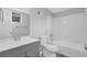 Well-lit bathroom features a vanity, toilet, and bathtub with white tile surround at 616 Country Lane Dr, Jonesboro, GA 30238