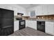 Cozy kitchen featuring white cabinets, black appliances, and neutral countertops at 616 Country Lane Dr, Jonesboro, GA 30238