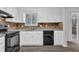 Bright kitchen with white cabinets, black dishwasher, and sliding door access at 616 Country Lane Dr, Jonesboro, GA 30238