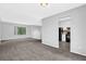 Bright living room with gray carpet and walls, with a partial view of the kitchen at 616 Country Lane Dr, Jonesboro, GA 30238