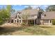 A large backyard featuring a covered patio, expansive windows, and a blooming tree at 2839 Echols Rd, Cumming, GA 30041