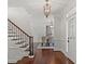 Inviting foyer with hardwood floors, staircase with iron railings, and elegant lighting at 2839 Echols Rd, Cumming, GA 30041