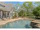 Inground pool with waterfall feature and a covered patio area with views of the backyard at 2839 Echols Rd, Cumming, GA 30041