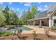 Backyard oasis with a pool, waterfall, and covered patio for outdoor entertaining at 2839 Echols Rd, Cumming, GA 30041