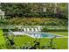 Professionally landscaped backyard with manicured lawn, trimmed hedges, pool, and lounge chairs at 315 Peachtree Battle Nw Ave, Atlanta, GA 30305