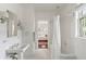 Traditional white-tiled bathroom with a pedestal sink, and shower featuring stylish sconces and decorative mirrors at 315 Peachtree Battle Nw Ave, Atlanta, GA 30305