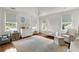 Bright bedroom with windows, neutral walls, light blue rug, and a chandelier providing gentle, ambient light at 315 Peachtree Battle Nw Ave, Atlanta, GA 30305