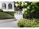 View of white garage doors surrounded by lush greenery and blooming white flowers at 315 Peachtree Battle Nw Ave, Atlanta, GA 30305