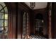 Stately hallway featuring dark wood paneling, arched doorways, and checkered tile flooring at 315 Peachtree Battle Nw Ave, Atlanta, GA 30305