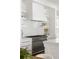 A bright white kitchen with a modern oven, white backsplash and floating shelves at 315 Peachtree Battle Nw Ave, Atlanta, GA 30305