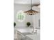 White kitchen with oval window, apron sink, white marble countertop, and modern black and gold chandelier at 315 Peachtree Battle Nw Ave, Atlanta, GA 30305