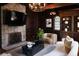 Inviting living room boasts stone fireplace, dark wood paneling, and stylish furnishings under chandelier lighting at 315 Peachtree Battle Nw Ave, Atlanta, GA 30305