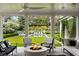 Covered outdoor living space with fire pit and furniture, overlooking a manicured backyard with pool at 315 Peachtree Battle Nw Ave, Atlanta, GA 30305