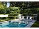 Refreshing swimming pool surrounded by manicured hedges, lush trees, and comfortable lounge chairs at 315 Peachtree Battle Nw Ave, Atlanta, GA 30305