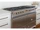 Close-up of stainless steel range with multiple burners, knobs and handles set into surrounding cabinetry at 315 Peachtree Battle Nw Ave, Atlanta, GA 30305